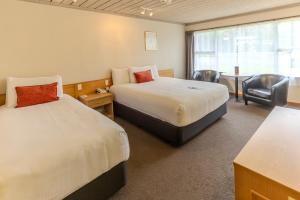 a hotel room with two beds and a table and chairs at Kingsgate Hotel Te Anau in Te Anau +34 photos
