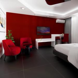 a bedroom with red walls and a bed and red chairs at Miami Apartments in St. Julianʼs