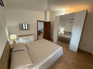 a bedroom with a large white bed and a mirror at Lo Stazzo di Gallura Rudalza-Porto Rotondo in Rudalza