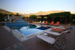 a swimming pool with lounge chairs and a swimming pool at Stephanou Inn in Agios Nikolaos