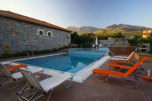 a group of chairs and a swimming pool at Stephanou Inn in Agios Nikolaos