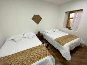 two beds sitting next to each other in a room at Casa Munay in Pasto