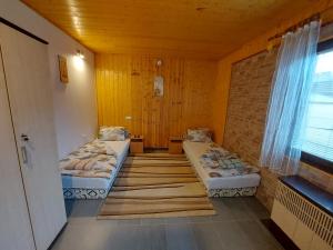a room with two beds and a window at Family vendégház in Túrkeve