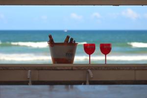 two wine glasses and a bucket of beer on the beach at VIRASSOL Praia Hotel in Salvador