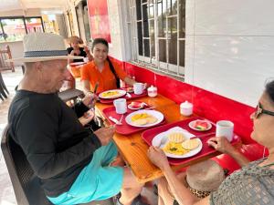 a group of people sitting around a table eating food at Sweet Caribbean Airport Hotel in San Andrés +36 photos