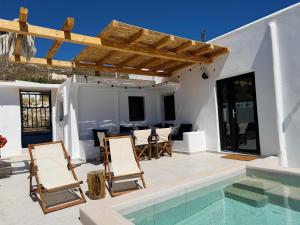 Kukulú Luxurious Cottage with Mini Private Pool في أنو ميرا: فناء مع كراسي وحمام سباحة