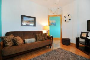 a living room with a brown couch and a television at Surround Sound in Nags Head