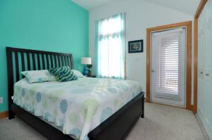 a bedroom with a bed with a blue wall at Surround Sound in Nags Head