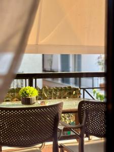 a table with two chairs and a potted plant on it at Green Suite Skiathos in Skiathos