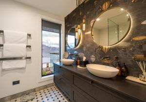 un bagno con due lavandini e un grande specchio di The Glasshouse by MajorDomo - Central Home with Hot Tub & Sauna a Queenstown Altre 57 foto