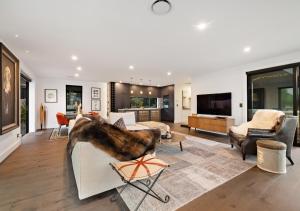 un soggiorno arredato con TV di The Glasshouse by MajorDomo - Central Home with Hot Tub & Sauna a Queenstown