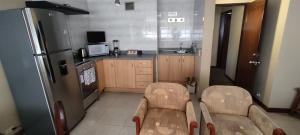a kitchen with a refrigerator and a table and chairs at Confortable apartamento en La Carolina in Quito