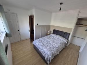 a bedroom with a bed in a white room at Rowell in Barking