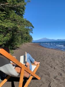 a man laying in a beach chair on the beach at Calma Lodge in Puerto Clocker