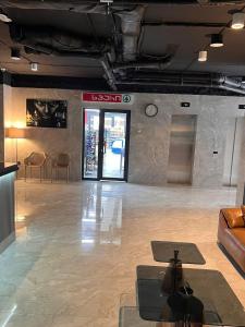 eine Lobby mit einem Sofa und einer Uhr an der Wand in der Unterkunft Premium apartment in Batumi 1718 in Batumi
