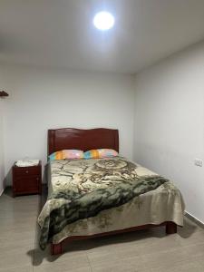 a bedroom with a bed in a white room at Hotel Buenos Aires in Pasto