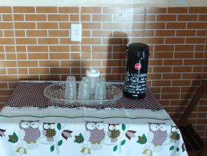 a table with a table cloth with an owl bottle on it at Hostel da Ladeira in Ouro Preto