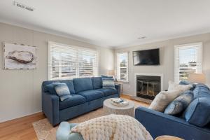 a living room with two blue couches and a fireplace at Slumbering Duck in Sanderling
