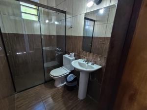 Un baño con inodoro, lavabo y ducha. en CEDE Inn Hotel, en Encarnación