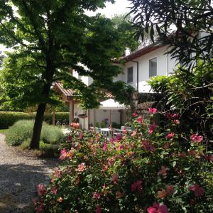 een wit huis met roze bloemen ervoor bij Bed and Breakfast Villa Gina in Zero Branco