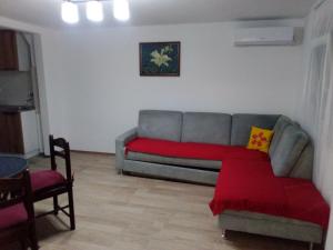 a living room with a couch and a red blanket at Vila FiDa in Gornja Toplica