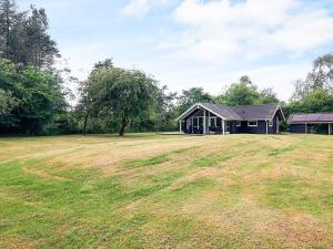 a house with a large field in front of it at 6 person holiday home in Asaa-By Traum in Aså