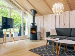 a living room with a couch and a fireplace at 6 person holiday home in Asaa-By Traum in Aså