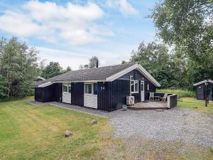 a black and white house with a yard at 6 person holiday home in Hadsund in Hadsund