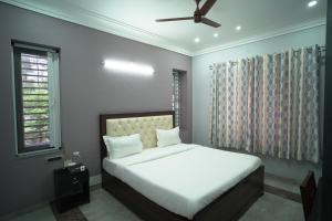 a bedroom with a white bed and a ceiling fan at Lakeside Bliss Homestay in Udaipur