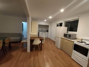 a kitchen and living room with a table and refrigerator at 3 Bedroom Serviced House A, 30 Laurel St in Auckland +11 photos
