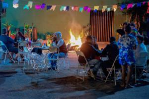 a group of people sitting around a fire at Pousada Quinta de Areal in Areal