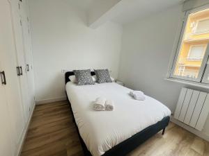 a small bedroom with a bed with shoes on it at Leña II - by Wehomes - Pleno centro in Santander