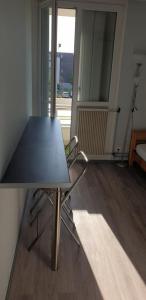 a table and chairs in a room with a window at Studio lit 90 avec balcon in Gradignan