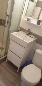 a bathroom with a white sink and a toilet at Studio lit 90 avec balcon in Gradignan