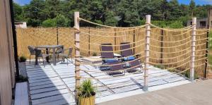 a patio with chairs and a table and a fence at Apartament Szyszka in Rogowo