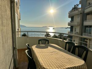 a table and chairs on a balcony with a view of the ocean at New Sea View Apartment Lungomare in Polisi i Vogël