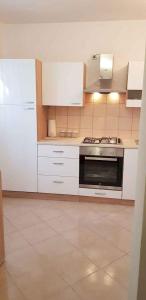 a kitchen with white cabinets and a stove top oven at Holiday home in Sv. Filip i Jakov 53896 in Sveti Filip i Jakov