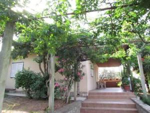 a porch of a house with stairs and trees at Holiday home in Sv. Filip i Jakov 53896 in Sveti Filip i Jakov