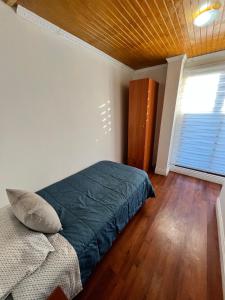 a bedroom with a green bed and a window at El secreto de la abuela spa in Talca
