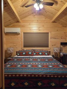 a bedroom with a bed with a ceiling fan at Flint Rock Cabins - The Arrow in Lonsdale +9 photos
