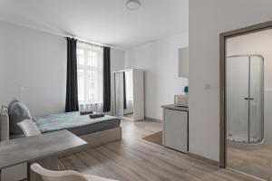 a white room with a bed and a kitchen at 70s Business Room in Krakow