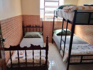 two bunk beds in a room with a brick wall at Hostel da Ladeira in Ouro Preto