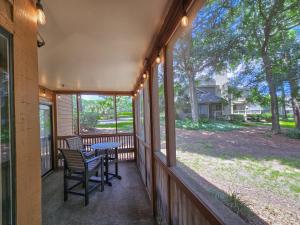 默特尔比奇Serene 2 bed, 2 bath lodge, with amenities, 101AC lodge的带纱窗的门廊，上面有桌子和椅子 更多37张照片