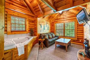 ein Wohnzimmer mit einer Badewanne, einem Sofa und einem TV in der Unterkunft The Fontana in Gatlinburg