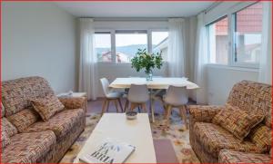 ein Wohnzimmer mit Sofa und einem Tisch mit Stühlen in der Unterkunft Apartamentos Gloria-patchwork-Ubiarco in Ubiarco