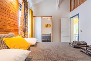 Un dormitorio con una cama grande con almohadas amarillas. en Villa Hibiscus - piscine privative, en Sainte-Anne