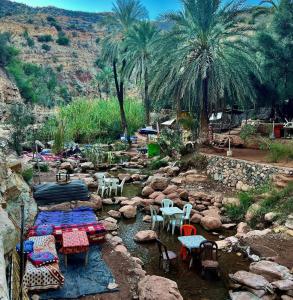 a group of tables and chairs in a river with rocks at Openwaves surf house in Agadir