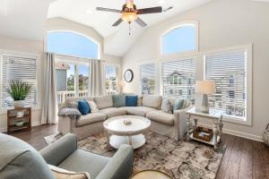 a living room with a couch and a ceiling fan at Stella Blue in Corolla