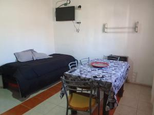 a room with a table and a bed and a table and chairs at MARY ORM House 2 in Malargüe