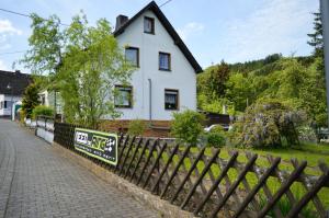 a white house with a fence in front of it at Franky House am Nürburgring in Quiddelbach